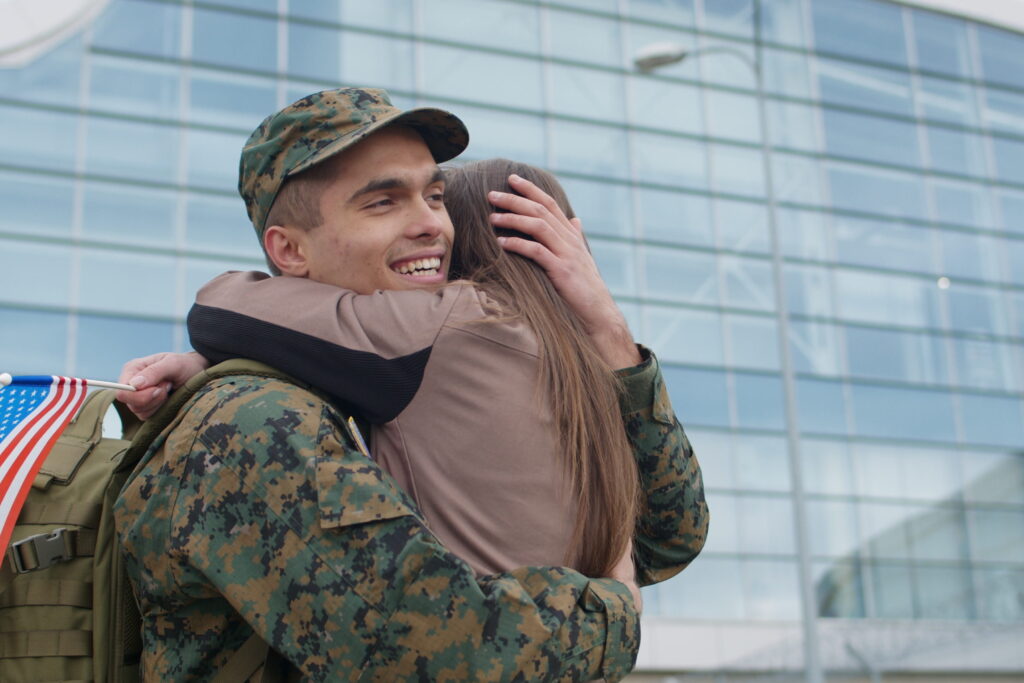 Marine soldier man embracing his girlfriend. Welcoming him home from deployment.